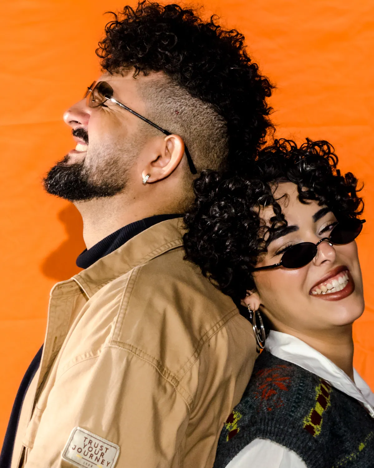 Elias e Flavy, vocalistas dos Bispos, de costas um para o outro, rindo